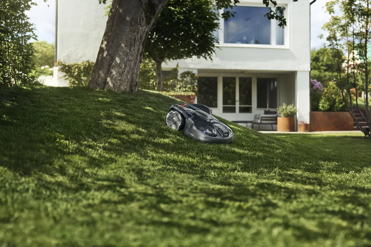 Seitz Gartenbau - Gartentechnik - Moderener Mähroboter fährt auf Rasenfläche