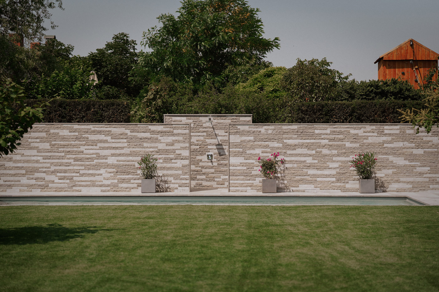 Seitz-Gartengestaltung - Steinmauer als Sichtschutz mit integrierter Dusche am Pool
