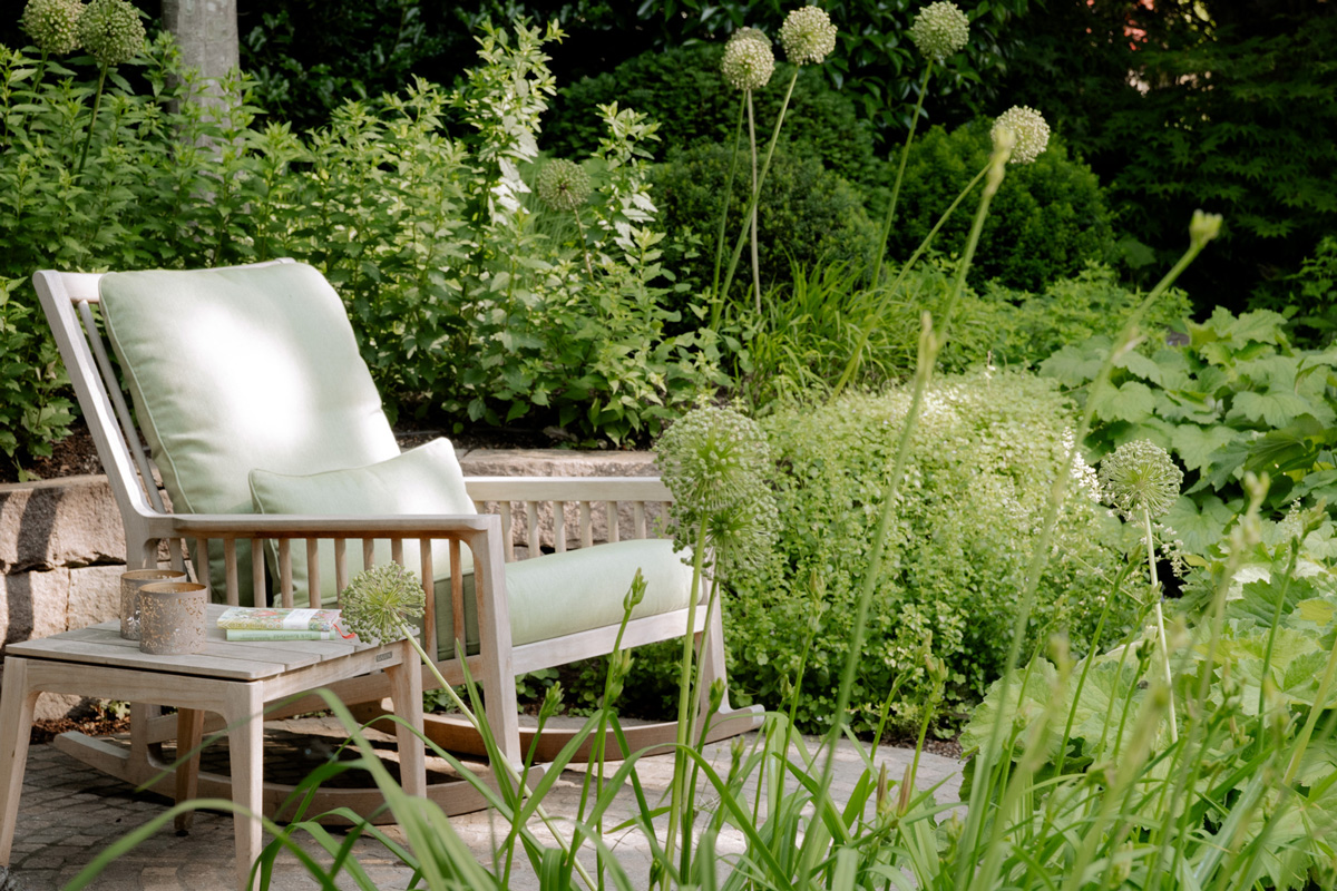 Sitzgelegenheit umgeben von üppiger, schattenspendender Bepflanzung