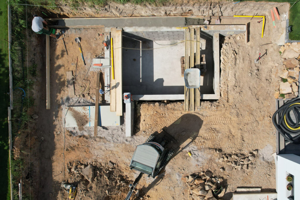 Baustelle für den Naturpool und Garten auf zwei ebenen mit üppiger bepflanzung und kebony holzdeck